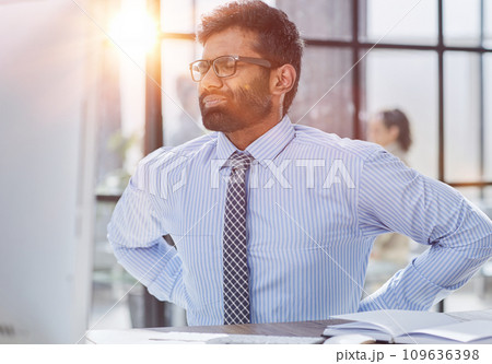Guy Having Backache Massaging Aching Lower Back Suffering From Pain Sitting At Workplace In Modern Office Guy Having Backache Massaging Aching Lower Back Suffering From Pain Sitting At Workplace In Modern Office 109636398