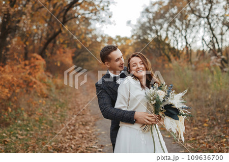 happy bride and groom enjoying romantic moments outside in autumn happy bride and groom enjoying romantic moments outside in autumn 109636700