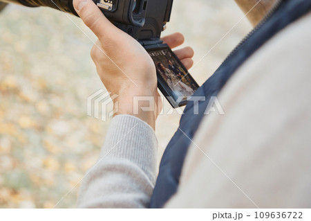 Professional wedding photographer holding camera against bride and groom Professional wedding photographer holding camera against bride and groom 109636722