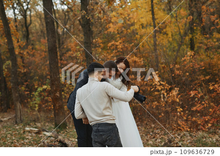 wedding photographer shows just taken photos to wedding couple. bride and groom in nature wedding photographer shows just taken photos to wedding couple. bride and groom in nature 109636729