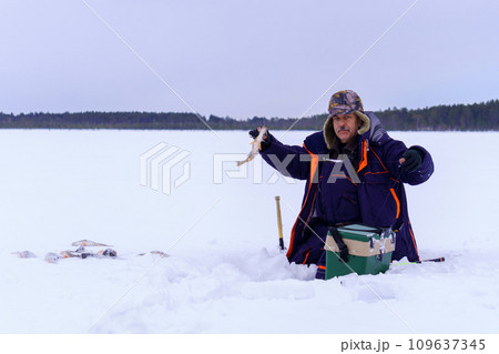 Man Holding a Fish in the Snow. Winter fishing, adventure. Banner, copy space 109637345