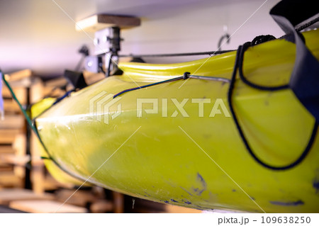 Selective focus on the side of a kayak that has used a Hoist and pulley system to store on the ceiling of a garage. Selective focus on the side of a kayak that has used a Hoist and pulley system to store on the ceiling of a garage. 109638250