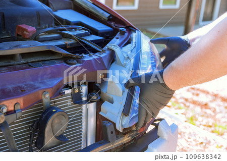 During service car repair, repairman assembles an automobile headlight 109638342
