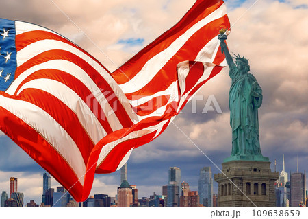 Featuring Statue of Liberty is beautifully waving American flag with Manhattan at New York City background 109638659