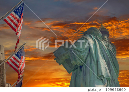 Statue of Liberty is framed by beautifully waving American flag during sunset 109638660