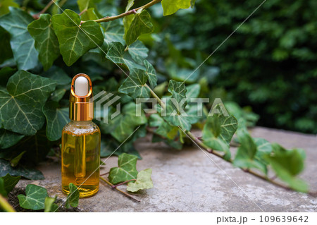 Dropper golden glass bottle with cosmetic oil or serum on nature background with copy space 109639642