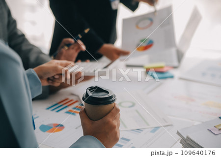 Financial analysts analyze business financial reports on a digital tablet planning investment project during a discussion at a meeting of corporate showing the results of their successful teamwork. 109640176
