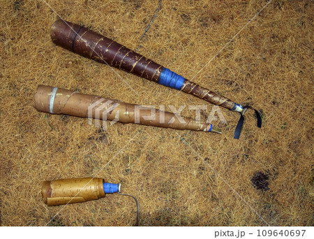 Pipes or decoys made of birch bark for hunting Siberian red deer on forest floor made of fallen larch needles. 109640697