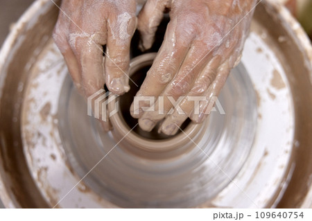 male hands making ceramic cup on pottery wheel, Close-up, top view. man making cup from clay pot male hands making ceramic cup on pottery wheel, Close-up, top view. man making cup from clay pot 109640754