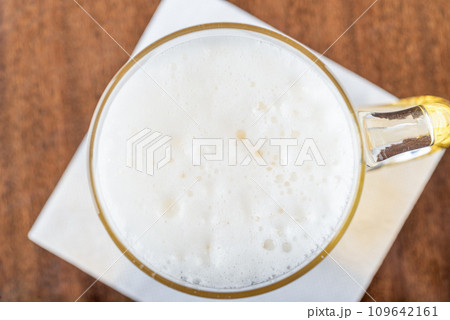 Top view of beer foam in a glass goblet with a handle. 109642161
