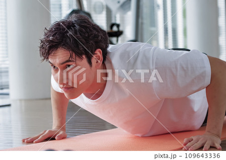 筋力トレーニングに励む若い男性 筋力トレーニングに励む若い男性 109643336