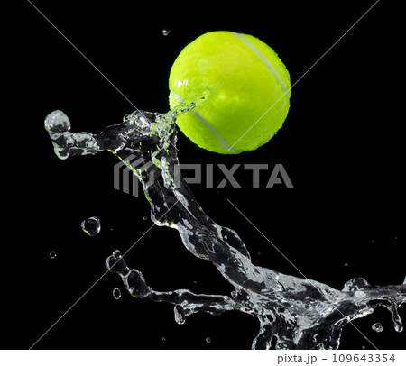 Tennis ball hit water and splash in air. Green Tennis ball fly in rain and splatter spin splash in droplet water. Black background isolated freeze action 109643354