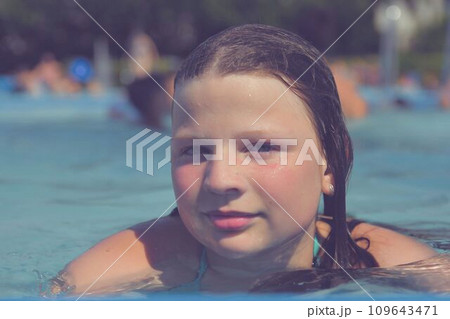 A picture of a little girl at a swimming pool in summer. A small girl swimming to the edge of a swimming pool at a swimming pool. Concept of summer, water fun, sun and relaxation A picture of a little girl at a swimming pool in summer. A small girl swimming to the edge of a swimming pool at a swimming pool. Concept of summer, water fun, sun and relaxation 109643471