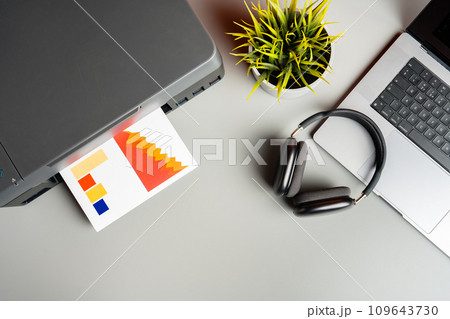 Modern printer with paper and laptop on table in office 109643730