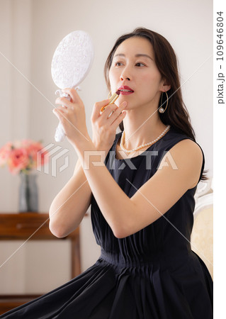女性のポートレート　鏡を見ながら口紅を塗る女性 109646804