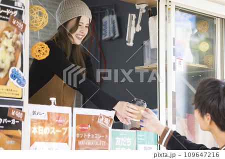 キッチンカーからお客さんにコーヒーを渡す店員さん キッチンカーからお客さんにコーヒーを渡す店員さん 109647216
