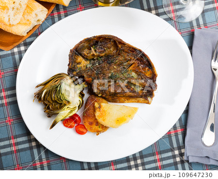 Cabeza de cordero - spanish dish. Lamb head with artichoke, tomatoes and potatoes Cabeza de cordero - spanish dish. Lamb head with artichoke, tomatoes and potatoes 109647230