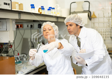 Man and woman scientists chemists conduct experiments in the laboratory Man and woman scientists chemists conduct experiments in the laboratory 109648135