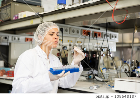 Focused female technician working in research laboratory Focused female technician working in research laboratory 109648187