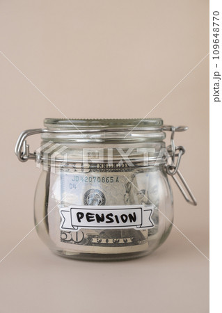 Glass jar full of American currency dollars cash banknote with text PENSION. Preparation saving money. Moderate consumption and economy 109648770