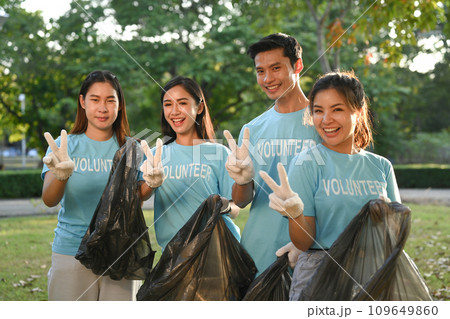 Group of young volunteer collecting trash in the park. Environmental protection and charity concept Group of young volunteer collecting trash in the park. Environmental protection and charity concept 109649860
