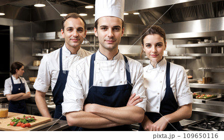 Portrait of chefs team in commercial kitchen. Happy chef working in kitchen at restaurant. smiling confident chefs standing at kitchen in restaurant 109650116