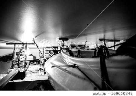 Selective focus on the side of a kayak that has used a Hoist and pulley system to store on the ceiling of a garage. 109650845