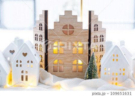 Cozy Christmas decor tiny house of small size on window sill with snow outside the window. Gift for New Year. Insurance, moving to new house, mortgage, rent and purchase real estate 109651631