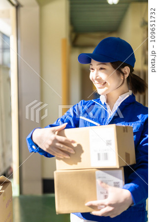 物流センターで荷物を運ぶ若い女性作業員 物流センターで荷物を運ぶ若い女性作業員 109651732