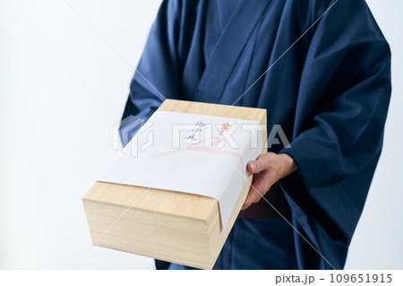 お中元を差し出す男性 109651915