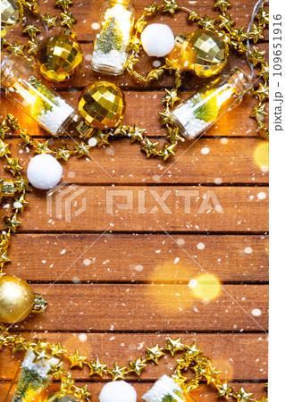 Festive frame with a place for Christmas and New Year's theme text. Sequins, stars, garland on brown wooden background. Copyspace, greeting card Festive frame with a place for Christmas and New Year's theme text. Sequins, stars, garland on brown wooden background. Copyspace, greeting card 109651916