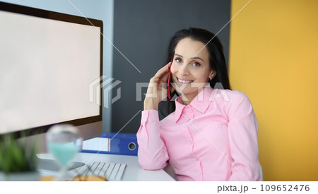 Young woman talking on cell phone in office 109652476