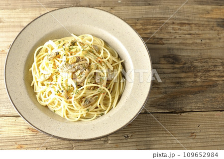 沢山のアサリと赤唐辛子、イタリアンパセリ、ガーリックチップの乗ったボンゴレビアンコを俯瞰で撮影 沢山のアサリと赤唐辛子、イタリアンパセリ、ガーリックチップの乗ったボンゴレビアンコを俯瞰で撮影 109652984