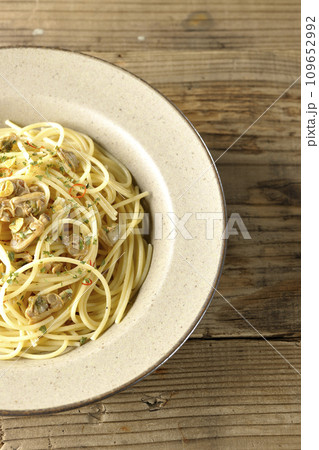 沢山のアサリと赤唐辛子、イタリアンパセリ、ガーリックチップの乗ったボンゴレビアンコを俯瞰で撮影 沢山のアサリと赤唐辛子、イタリアンパセリ、ガーリックチップの乗ったボンゴレビアンコを俯瞰で撮影 109652992