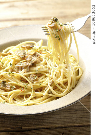 沢山のアサリと赤唐辛子、イタリアンパセリ、ガーリックチップの乗ったボンゴレビアンコを食べる 109653053