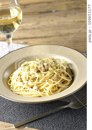 沢山のアサリと赤唐辛子、イタリアンパセリ、ガーリックチップの乗ったボンゴレビアンコと白ワイン 109653177