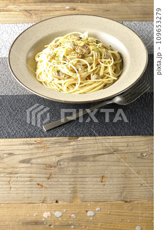 沢山のアサリと赤唐辛子、イタリアンパセリ、ガーリックチップの乗ったボンゴレビアンコ 109653279