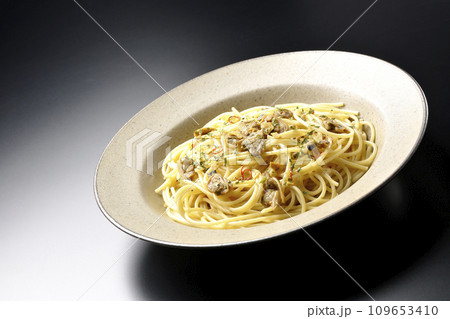 沢山のアサリと赤唐辛子、イタリアンパセリ、ガーリックチップの乗ったボンゴレビアンコを黒背景で撮影 109653410