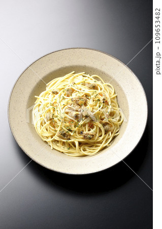 沢山のアサリと赤唐辛子、イタリアンパセリ、ガーリックチップの乗ったボンゴレビアンコを黒背景で俯瞰撮影 沢山のアサリと赤唐辛子、イタリアンパセリ、ガーリックチップの乗ったボンゴレビアンコを黒背景で俯瞰撮影 109653482