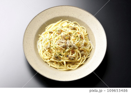 沢山のアサリと赤唐辛子、イタリアンパセリ、ガーリックチップの乗ったボンゴレビアンコを黒背景で俯瞰撮影 沢山のアサリと赤唐辛子、イタリアンパセリ、ガーリックチップの乗ったボンゴレビアンコを黒背景で俯瞰撮影 109653486