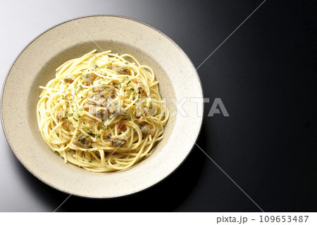 沢山のアサリと赤唐辛子、イタリアンパセリ、ガーリックチップの乗ったボンゴレビアンコを黒背景で俯瞰撮影 109653487