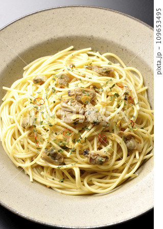 沢山のアサリと赤唐辛子、イタリアンパセリ、ガーリックチップの乗ったボンゴレビアンコを黒背景で俯瞰撮影 沢山のアサリと赤唐辛子、イタリアンパセリ、ガーリックチップの乗ったボンゴレビアンコを黒背景で俯瞰撮影 109653495