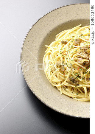 沢山のアサリと赤唐辛子、イタリアンパセリ、ガーリックチップの乗ったボンゴレビアンコを黒背景で俯瞰撮影 沢山のアサリと赤唐辛子、イタリアンパセリ、ガーリックチップの乗ったボンゴレビアンコを黒背景で俯瞰撮影 109653496