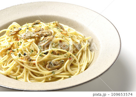 沢山のアサリと赤唐辛子、イタリアンパセリ、ガーリックチップの乗ったボンゴレビアンコを白背景で撮影 沢山のアサリと赤唐辛子、イタリアンパセリ、ガーリックチップの乗ったボンゴレビアンコを白背景で撮影 109653574