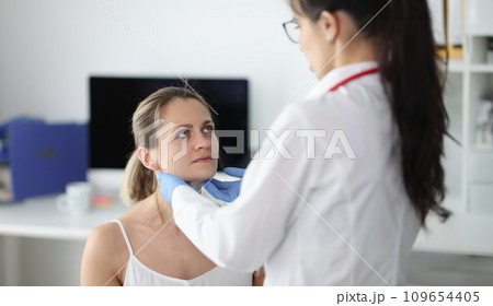 Doctor examining patients submandibular lymph nodes in clinic 109654405