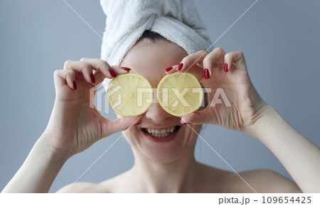 Young woman holding lemons in front of her eyes 109654425