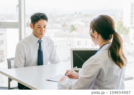 病気の病名告知をされてショックを受ける男性と医者 109654987