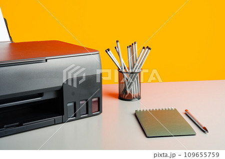 Laser printer on desk against yellow background. Laser printer on desk against yellow background. 109655759