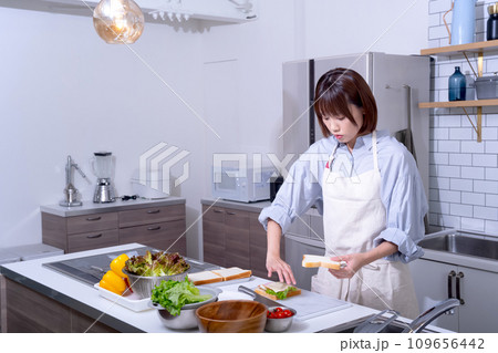 キッチンでサンドイッチを作る女性 キッチンでサンドイッチを作る女性 109656442