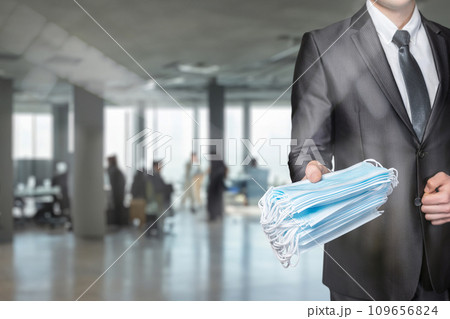 The manager hands out a pack of protective masks. 109656824